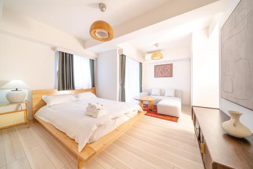 a white bedroom with a bed and a television at TORA HOTEL Sensoji 寅ホテル 浅草寺 in Tokyo