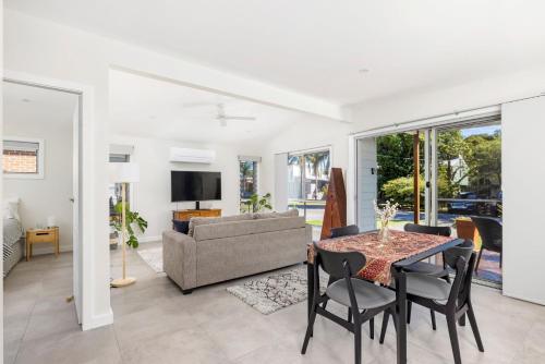 a living room with a table and a couch at Taylors Beach Cottage in Taylors Beach