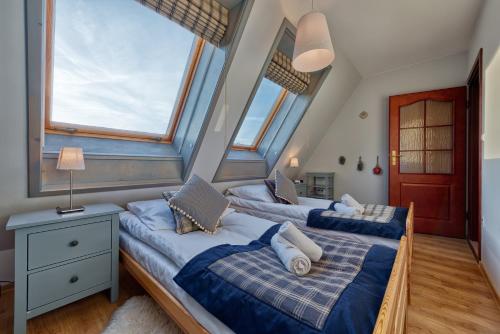 two beds in a room with two windows at Apartament Pardałówka Prestige in Zakopane