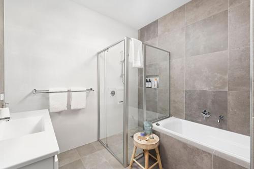 a bathroom with a shower and a tub and a sink at Comfort Luxury and Surrounded by Popular Beaches in Boat Harbour