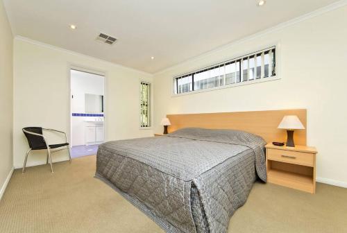 a bedroom with a bed and a desk and a window at Close to Little Beach and Shoal Bay Beach in Nelson Bay