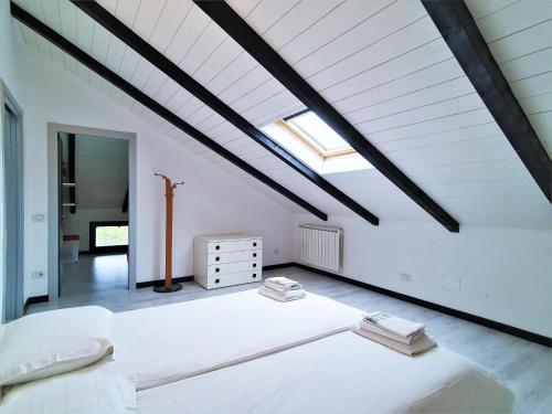 - une chambre mansardée avec un grand lit blanc dans l'établissement Belvilla by OYO ROG04 - Casa Roggiano, à Brissago Valtravaglia