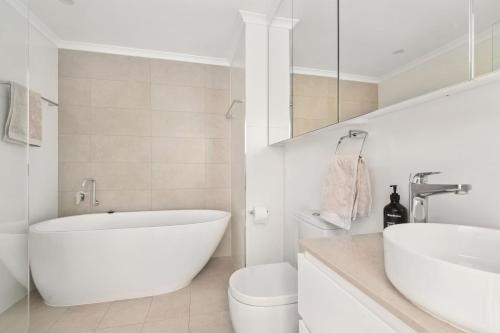 ショール・ベイにあるAura 3 Spectacular Beachside Viewsの浴槽、トイレ、洗面台を備えた白いバスルーム