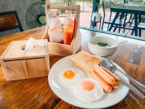 einen Teller Eier und Toast auf dem Tisch in der Unterkunft SkyHome Wat JD I- Khai Resort & Restaurant in Ban Wat Boek