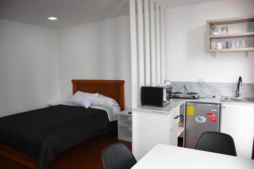 a small room with a bed and a kitchen at Mini Suites Cuarto Piso Alkimya in Loja