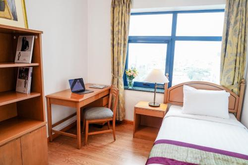 a bedroom with a bed and a desk and a window at Daeha Serviced Apartment in Hanoi
