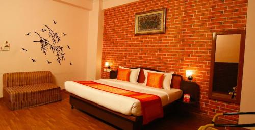 a bedroom with a bed and a brick wall at Hotel Manohar Palace in Jaipur