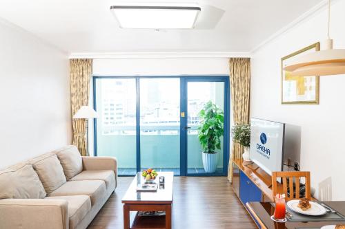 a living room with a couch and a tv at Daeha Serviced Apartment in Hanoi