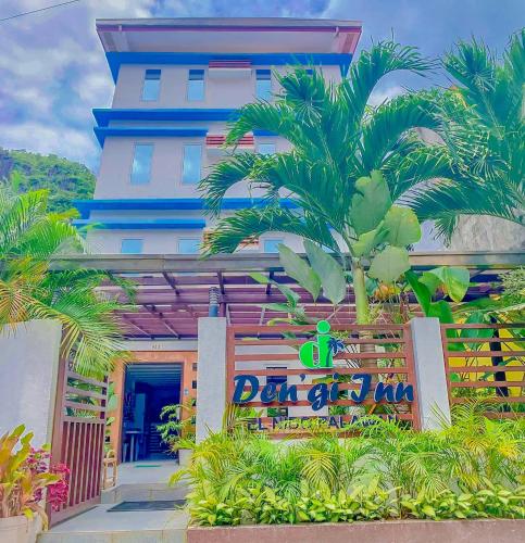 a building with a palm tree in front of it at DENGI INN EL NIDO in El Nido