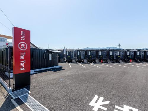 een parkeerplaats met rijen containers op een luchthaven bij HOTEL R9 The Yard Izumi in Izumi