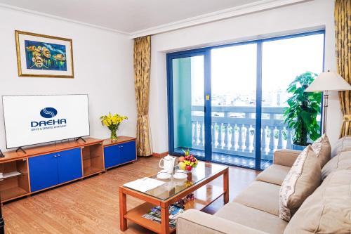 a living room with a couch and a tv at Daeha Serviced Apartment in Hanoi