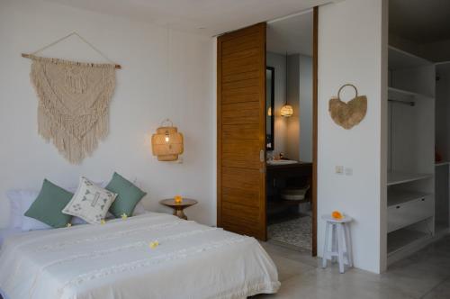 a bedroom with a white bed and a desk at The Bed by The Sea in Canggu