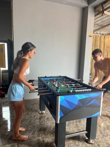 a man and a woman standing next to a foosball table at Vang Vieng Chill House in Vang Vieng