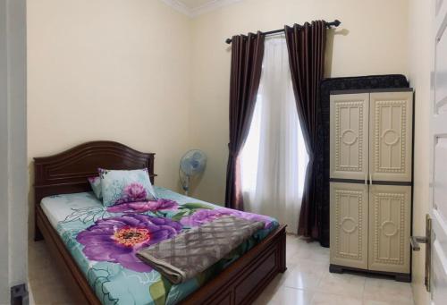 Un dormitorio con una cama con una flor. en Vila Anggur Pintukabun, en Bukittinggi