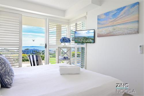 a bedroom with a large white bed and a large window at Crest Premium View Apartment 19 in Noosa Heads