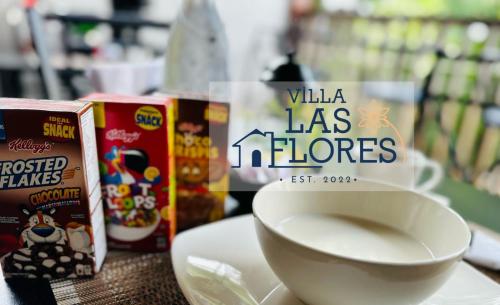 Eine weiße Schüssel stand auf einem Tisch neben einem Behälter mit Milch. in der Unterkunft Villa Las Flores in San Salvador