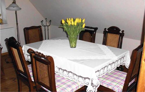 a table with a vase of yellow flowers on it at 3 Bedroom Gorgeous Apartment In Altenmedingen in Altenmedingen