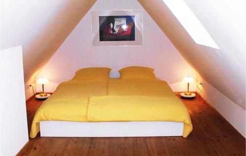 sypialnia z żółtym łóżkiem na poddaszu w obiekcie 3 Bedroom Gorgeous Apartment In Altenmedingen w mieście Altenmedingen