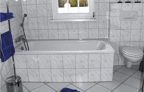 ein Bad mit einer Badewanne, einem WC und einem Fenster in der Unterkunft Amazing Apartment In Altenmedingen With 2 Bedrooms And Wifi in Altenmedingen