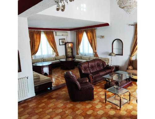 salon z kanapą i stołem w obiekcie Villa Lorangeraie, Wilaya de Tlemcen w mieście Tilimsan