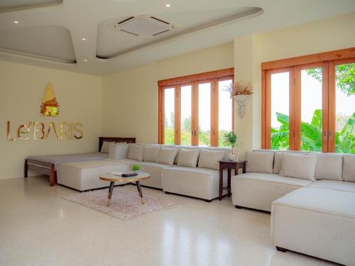 a living room with white furniture and windows at Nichahome Luxury Villa in Hua Hin
