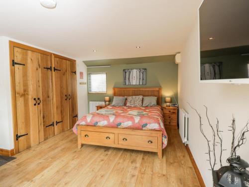 a bedroom with a bed and a wooden floor at The Pheasant's Nest in Welland