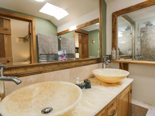 a bathroom with two sinks and a large mirror at The Pheasant's Nest in Welland