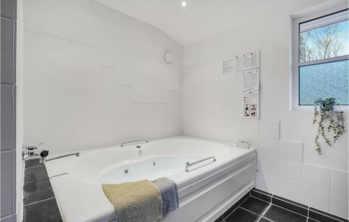 eine weiße Badewanne im Bad mit Fenster in der Unterkunft Beautiful Home In Ebeltoft With 5 Bedrooms, Sauna And Wifi in Ebeltoft