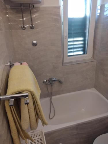 ein Bad mit einer Badewanne und einem Handtuch in der Unterkunft Apartment and rooms Hvar Limoni accessible today in Hvar