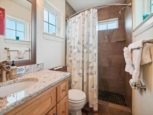 een badkamer met een douche, een toilet en een wastafel bij Beach Rays in Galveston