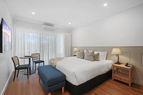 a bedroom with a bed and a table and chairs at Clare Country Club in Clare