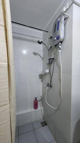 a bathroom with a shower with a phone on the wall at Denise's Midtown Condo in Davao City