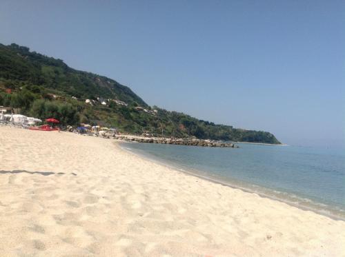 a beach with a lot of sand and the water at Residenza Villa Spagnola in Parghelia