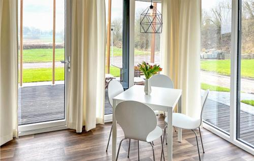 uma sala de jantar com uma mesa e cadeiras brancas e portas de vidro deslizantes em Beautiful Home In Ssel With Kitchen em Süsel
