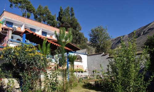uma vista para a casa a partir do jardim em La Finca Tarma em Tarma