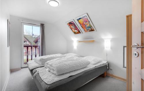 a bedroom with a bed with white sheets and a window at Awesome Home In Rm With 3 Bedrooms And Wifi in Bolilmark