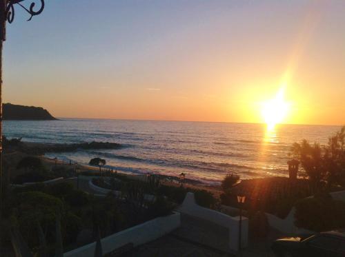 a sunset over the ocean with the sun setting at Residenza Villa Spagnola in Parghelia