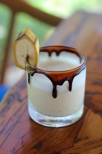 a drink in a glass with a slice of banana at Sagara Candidasa by AHM in Candidasa