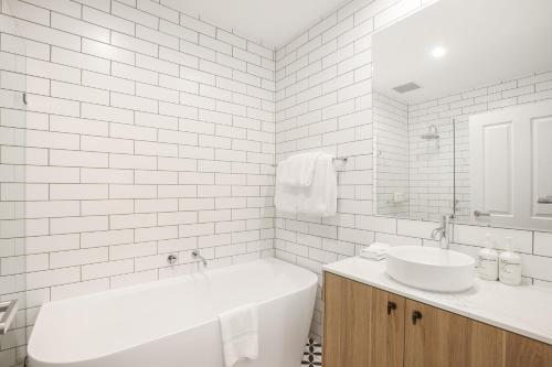 a white bathroom with a tub and a sink at Clare Country Club in Clare
