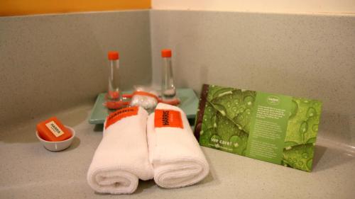 un par de toallas blancas en el lavabo del baño en HARRIS Hotel Batam Center en Batam Center