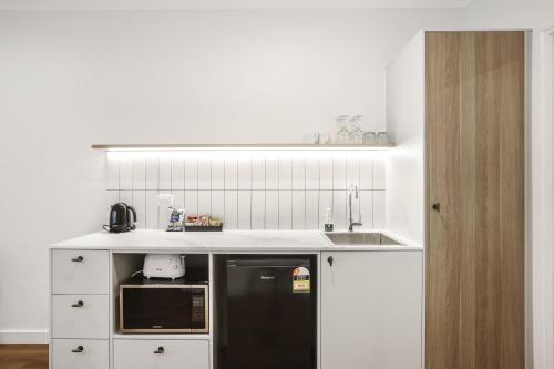 a kitchen with white cabinets and a black refrigerator at Clare Country Club in Clare