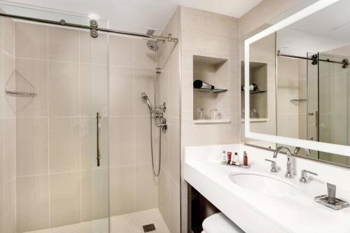 W łazience znajduje się prysznic, umywalka i lustro. w obiekcie Nashville Marriott at Vanderbilt University w mieście Nashville