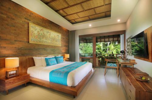 a bedroom with a large bed and a desk at Sagara Candidasa in Candidasa
