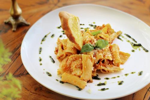 a plate of pasta on a wooden table at Sagara Candidasa by AHM in Candidasa