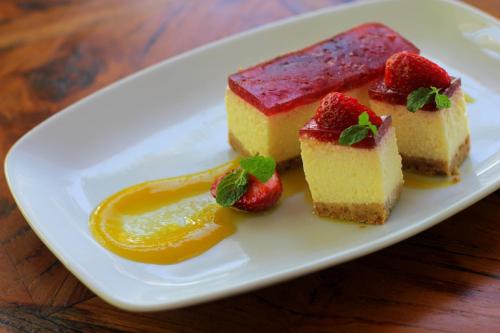 a plate with three pieces of cake with strawberries and honey at Sagara Candidasa by AHM in Candidasa