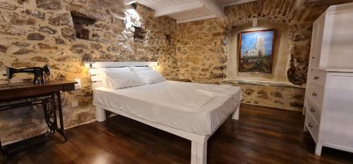 a bedroom with a bed in a stone wall at Olive oil mill in Kokkala