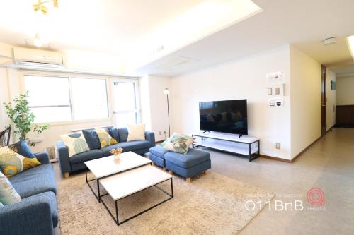 a living room with couches and a flat screen tv at NK BLD3F Sapporo 3LDK 3BR 1 floor 1 room in Minami-jūichijō