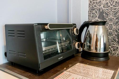 a toaster oven sitting on top of a table at Sweetloft Hotel Don Muang in Bangkok