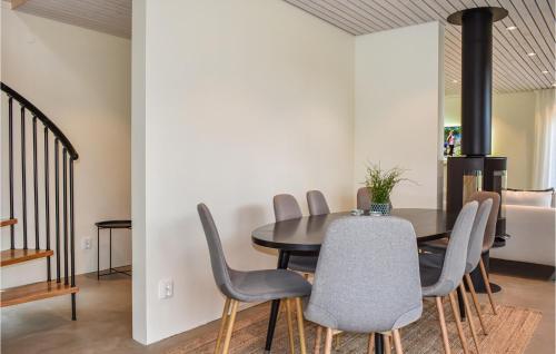 a dining room with a black table and chairs at 4 Bedroom Stunning Home In Ystad in Ystad