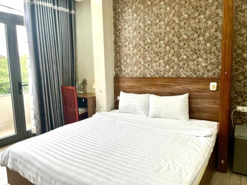 a bedroom with a large bed with a wooden headboard at Shine Hotel in Hue